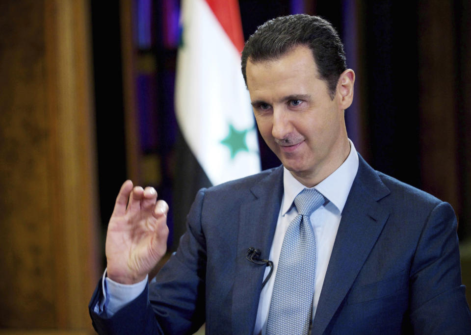 FILE - In this Feb. 10, 2015, file photo released by the Syrian official news agency SANA, Syrian President Bashar Assad gestures during an interview in Damascus, Syria. Assad has snapped up a prize from world powers that have been maneuvering in his country’s multifront wars. Without firing a shot, his forces are returning to towns and villages in northeastern Syria where they haven’t set foot for years. (SANA via AP, File)