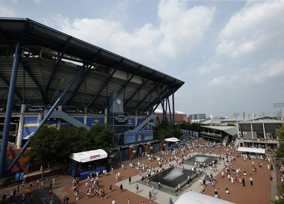 FILE - In this Aug. 27, 2018, file photo, fans walk outside of Arthur Ashe Stadium during the first round of the U.S. Open tennis tournament in New York. Governor Andrew Cuomo announced, Tuesday, June 16, 2020, that the U.S. Open will be played in Queens from Aug. 31 to Sept. 13, but without fans in attendance. (AP Photo/Jason DeCrow, File)