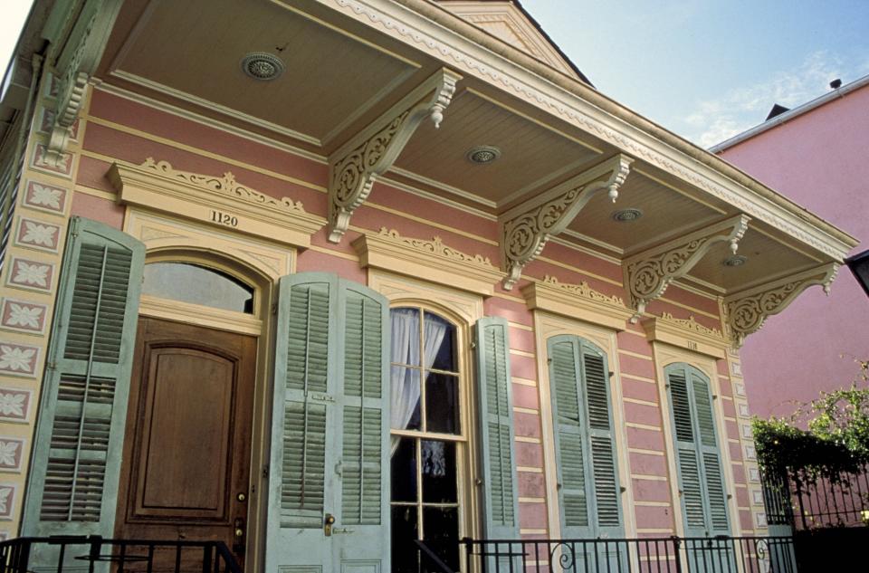 The exterior of a Creole cottage with Victorian trimmings on New Orleans's Dauphine Street in the French Quarter.