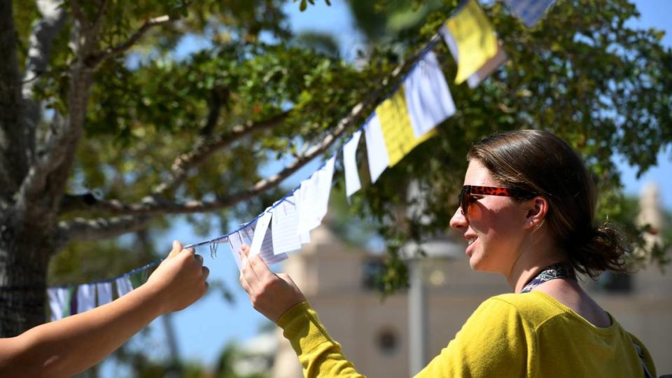 Olivia, a political science student at New College, reads notes written by students on why they love their school in front of the Cook Library as students participated in a one-hour walkout to protest DeSantis’ recent education-related policies.