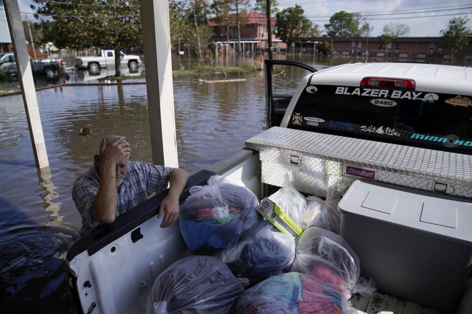 A man rests while helping neighbors at a home damaged in Hurricane Ida, Wednesday, Sept. 1, 2021, in Jean Lafitte, La. Louisiana residents still reeling from flooding and damage caused by Hurricane Ida scrambled Wednesday for food, gas, water and relief from the sweltering heat as thousands of line workers toiled to restore electricity and officials vowed to set up more sites where people could get free meals and cool off. (AP Photo/John Locher)