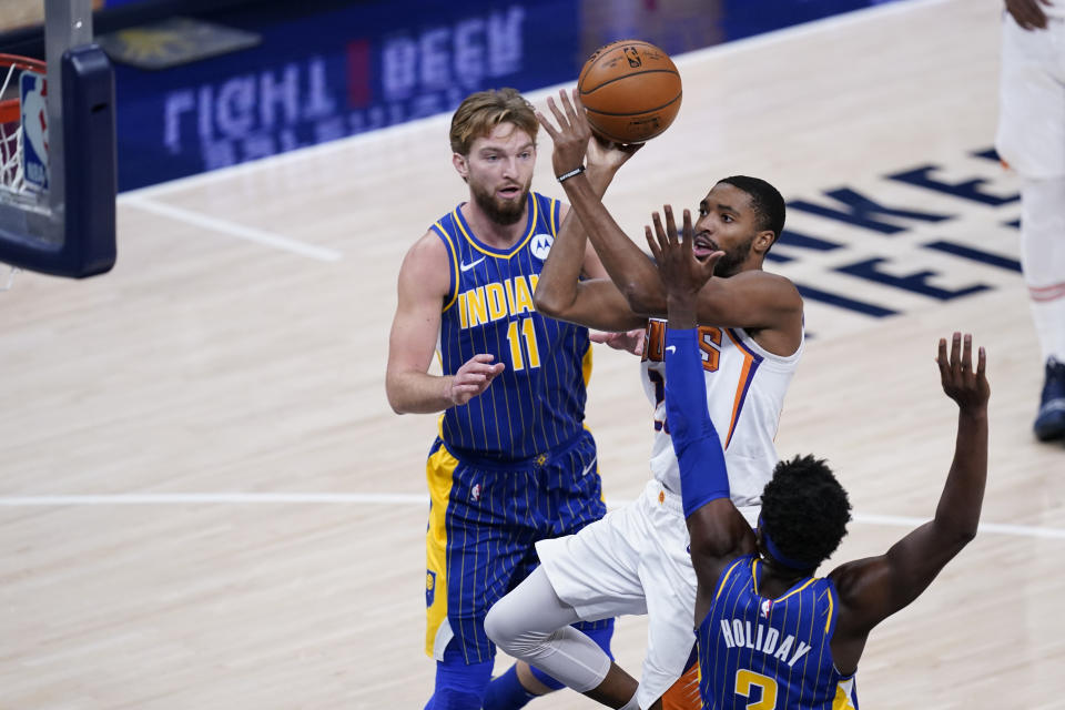 Phoenix Suns' Mikal Bridges (25) shoots against Indiana Pacers' Aaron Holiday (3) during the first half of an NBA basketball game, Saturday, Jan. 9, 2021, in Indianapolis. (AP Photo/Darron Cummings)