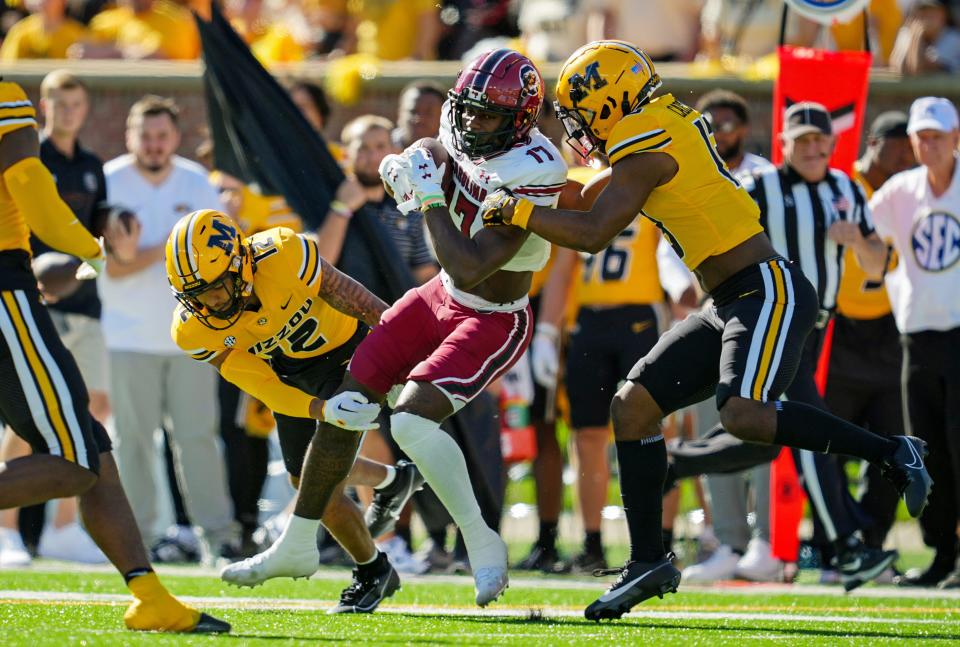 Oct 21, 2023; Columbia, Missouri, USA; South Carolina Gamecocks wide receiver Xavier Legette (17) is tackled by Missouri Tigers defensive back Dreyden Norwood (12) and defensive back Daylan Carnell (13) during the first half at Faurot Field at Memorial Stadium. Mandatory Credit: Jay Biggerstaff-USA TODAY Sports