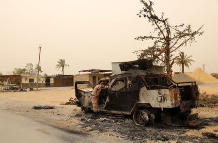 A member of the Libyan internationally recognised government inspects a damaged military vehicle during the fighting with the Eastern forces in Ain Zara, in Tripoli, Libya April 21, 2019. REUTERS/Ahmed Jadallah