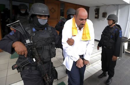 Death row inmate Serge Atlaoui of France (C) is escorted by police as he leaves Tangerang District Court after signing documents for his judicial review in Tangerang, Banten province April 1, 2015. REUTERS/Beawiharta