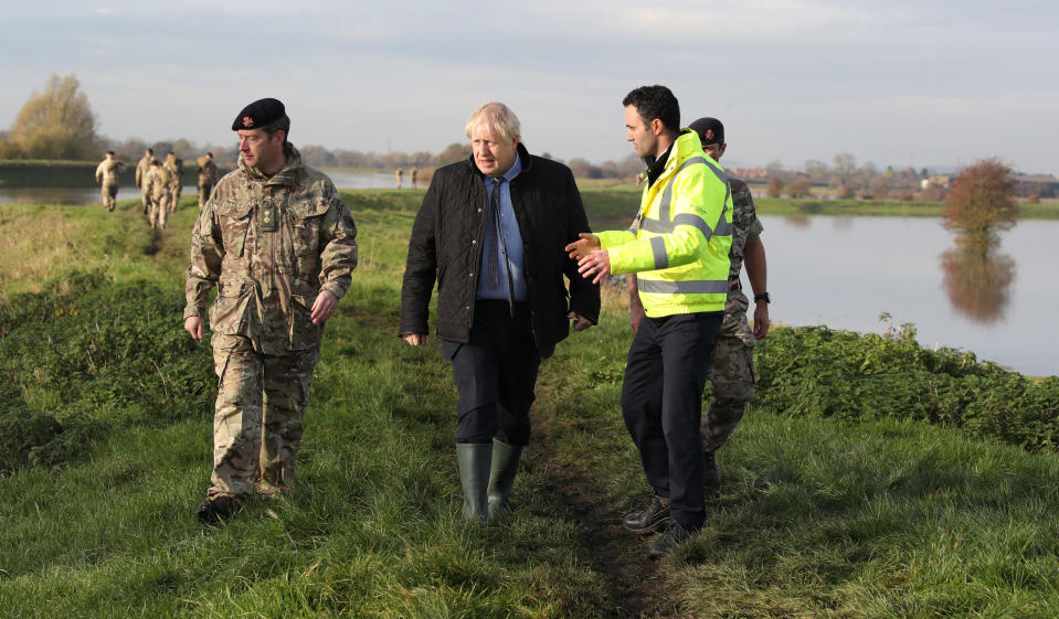 Britain's Prime Minister Boris Johnson (C) walks with Lt Col Tom Robinson (L) of the Light Dragoons and Oliver Harmar, Yorkshire Area Director of the Environment Agency as he visits Stainforth near Doncaster, northern England, on November 13, 2019, following flooding caused by days of heavy rain, and the River Don bursting its banks. (Photo by Danny Lawson / POOL / AFP) (Photo by DANNY LAWSON/POOL/AFP via Getty Images)