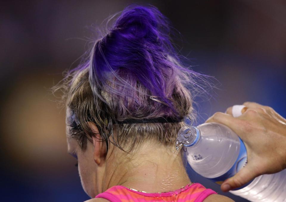 Bethanie Mattek-Sands of the U.S. pours water to her neck as she sits in her chair between games during her first round match against Maria Sharapova of Russia at the Australian Open tennis championship in Melbourne, Australia, Tuesday, Jan. 14, 2014.(AP Photo/Aaron Favila)