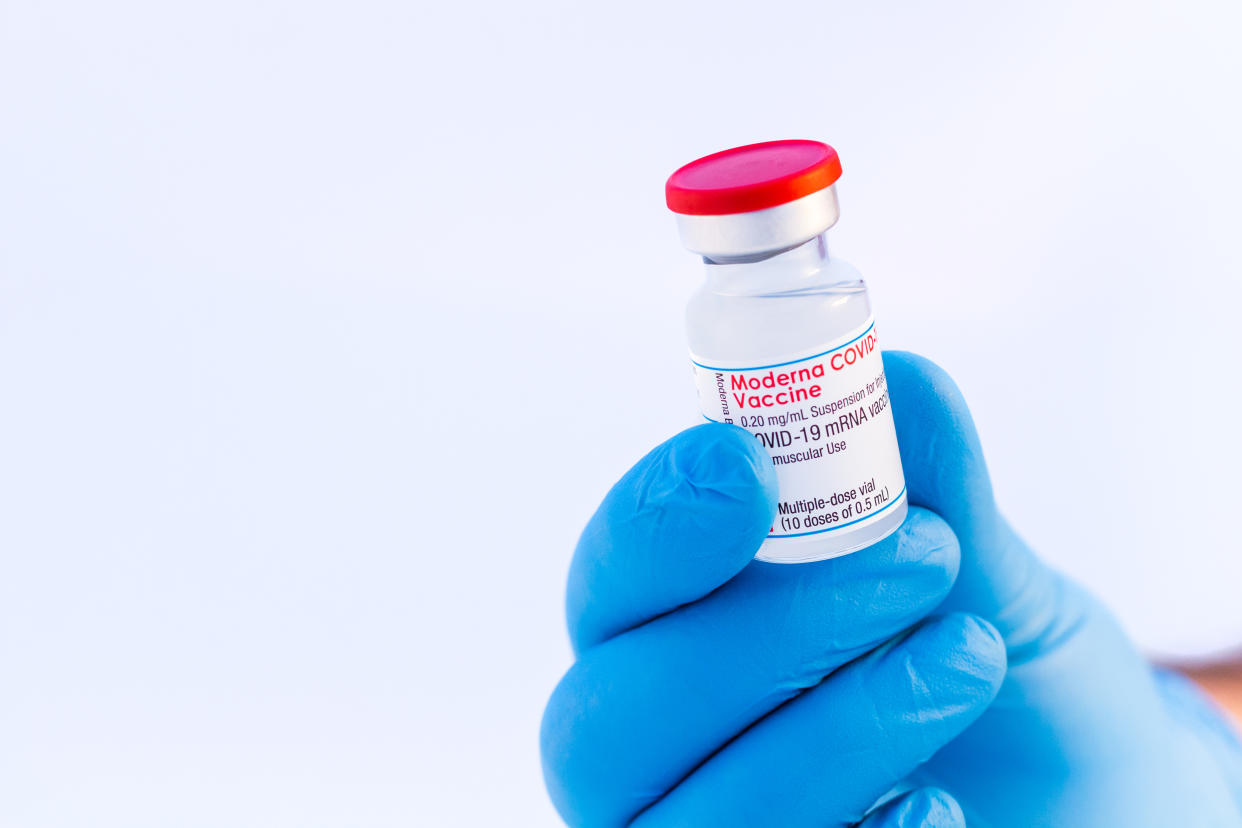 Brasov, Romania - February 21, 2021: Doctor or scientist holding Moderna Covid-19 vaccine on a white background.