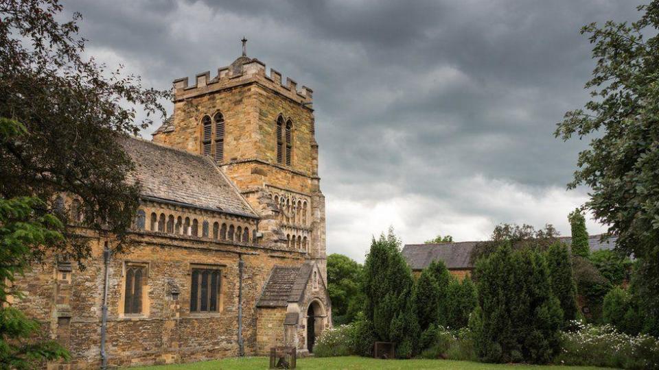 Medieval stone-built church with grass and trees