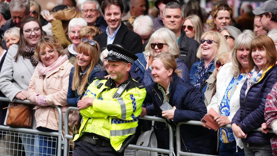 A police officer leans into a crowd of well-wishers at the wedding of the Duke of Westminster in Chester