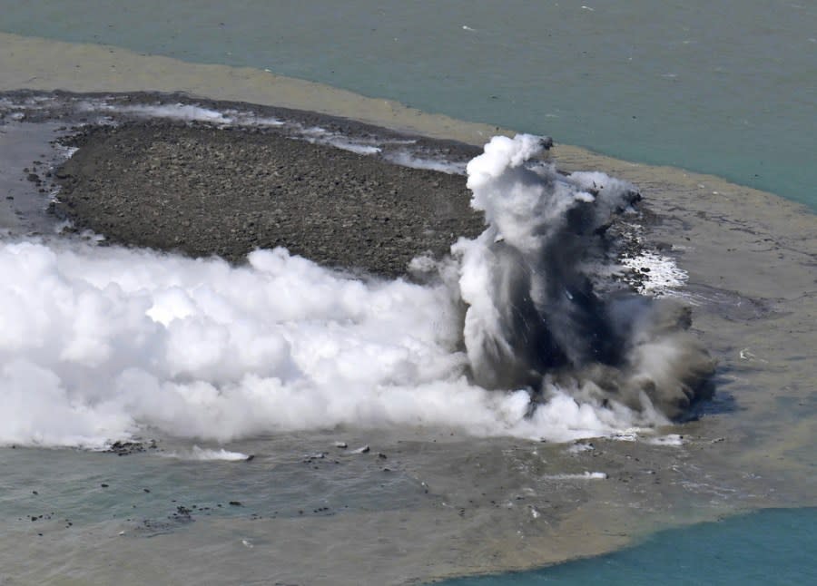 This aerial photo shows steam billowing from the waters off Iwoto Island, Ogasawara town in the Pacific Ocean, southern Tokyo, on Oct. 30, 2023. A new island, 100 meters in diameter, formed by erupted rock, is seen near the steam, according to Kyodo News. (Kyodo News via AP)