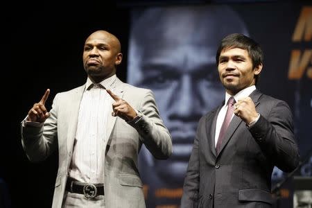 Eleven-time, five-division world boxing champion Floyd "Money" Mayweather (L) and eight-division world champion Manny "Pac-Man" Pacquiao pose at a news conference ahead of their upcoming bout, in Los Angeles, California March 11, 2015. REUTERS/Lucy Nicholson