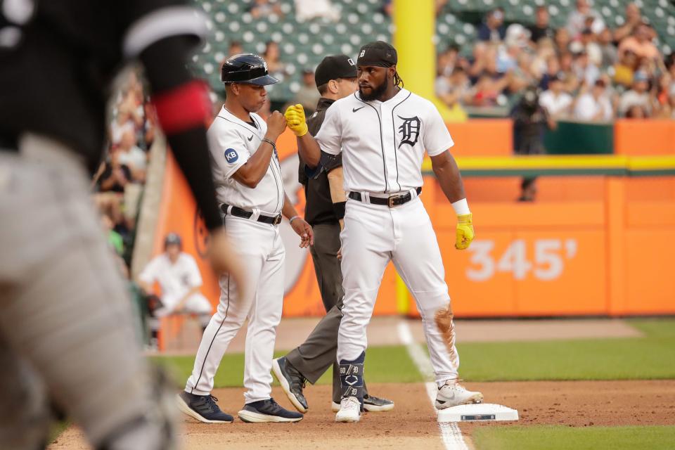 Tigers center fielder Akil Baddoo first bumps third base coach Ramon Santiago after hitting a triple against the White Sox during the third inning Sept. 17, 2022 at Comerica Park.