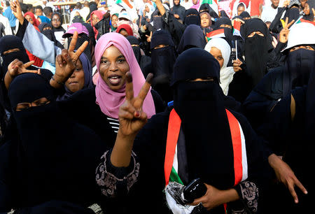 Sudanese demonstrators show their two finger salute as they arrive for the sit-in protest outside Defence Ministry in Khartoum, Sudan April 20, 2019. REUTERS/Mohamed Nureldin Abdallah