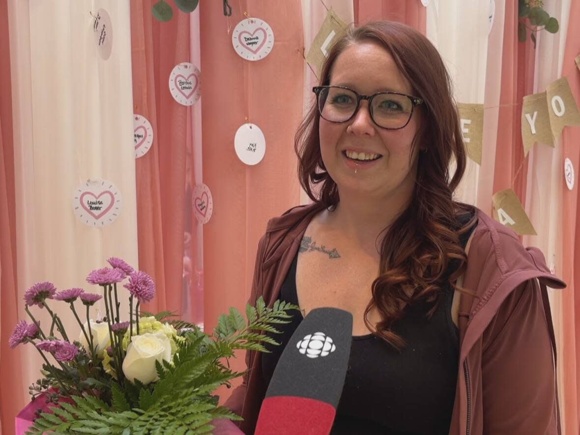 Lennea Blanchard holds flowers chosen by her son, Graycen, at the Love You Mama charity event for kids of single mothers. (Emily Fitzpatrick/CBC - image credit)