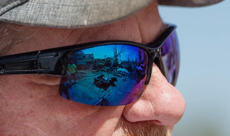 The remains of the home of Melissa Pierce and her husband L.A. Pierce on 7th Street in Rolling Fork is reflected in the glasses of James Brown, Melissa Pierce's brother.