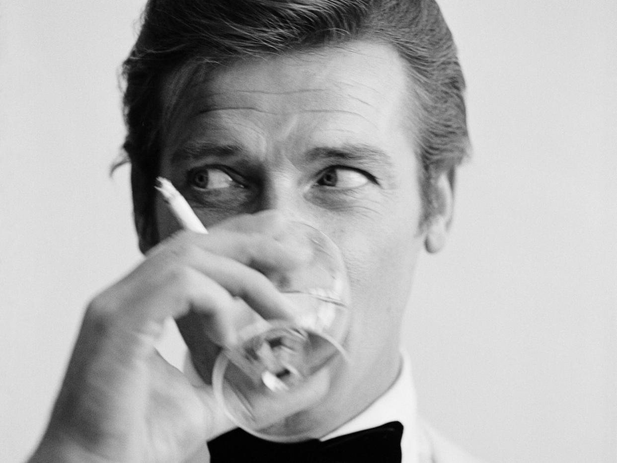 Roger Moore enjoys a cigarette and a martini during a 1968 photoshoot: Peter Ruck/BIPs/Getty Images