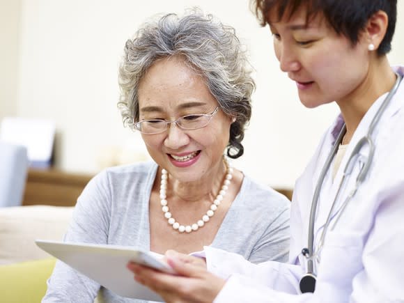 Older patient looking at a chart with her doctor.