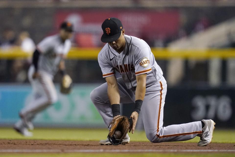 San Francisco Giants first baseman LaMonte Wade Jr fields a grounder hit by Arizona Diamondbacks' Pavin Smith before jogging to first base to get Smith out during the third inning of a baseball game Thursday, July 1, 2021, in Phoenix. (AP Photo/Ross D. Franklin)