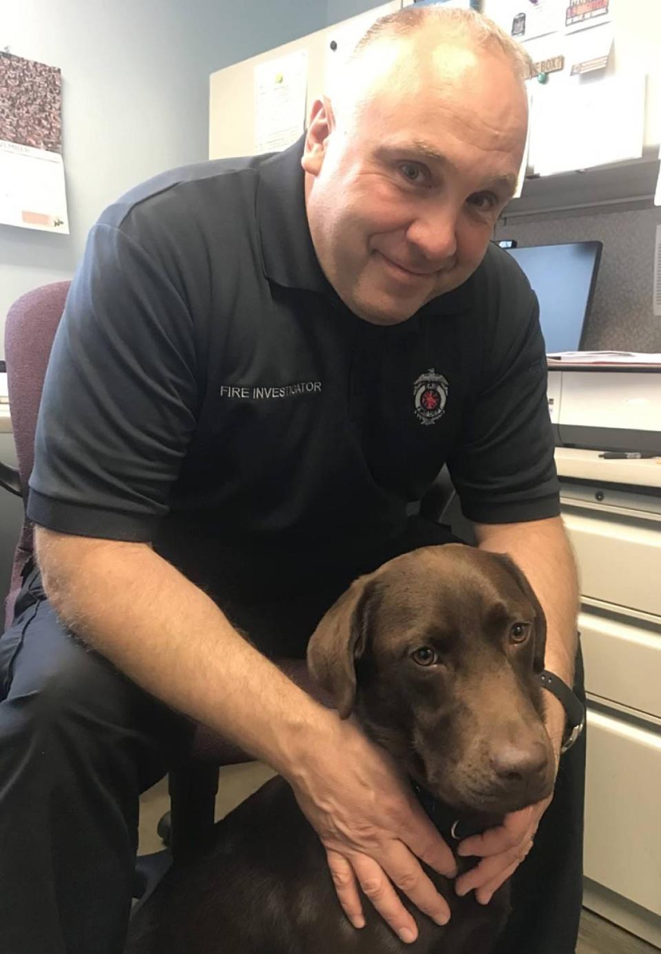 Erie Bureau of Fire Capt. Adam Gatti has partnered with Horus, a 1 1/2-year-old chocolate Labrador Retriever, to assist in fire investigations in Erie and surrounding areas. Horus, shown here with Gatti on Tuesday, is trained in accelerant detection, and has come to the city at no charge through a Federal Bureau of Alcohol, Tobacco, Firearms and Explosives program.