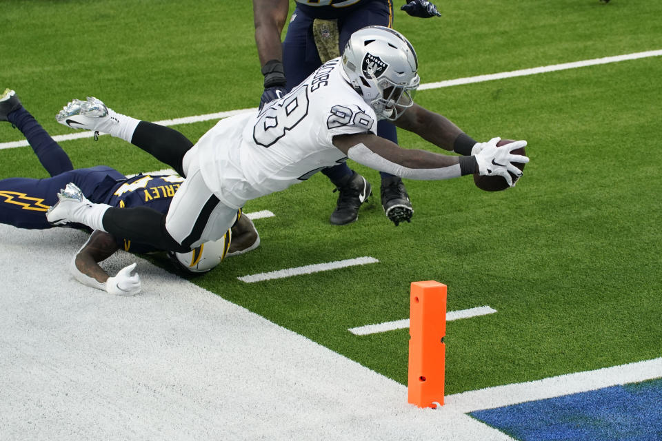 Las Vegas Raiders running back Josh Jacobs (28) scores a touchdown during the first half of an NFL football game against the Los Angeles Chargers, Sunday, Nov. 8, 2020, in Inglewood, Calif. (AP Photo/Ashley Landis)