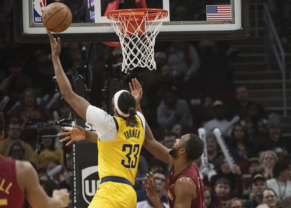 Indiana Pacers' Myles Turner (33) shoots as Cleveland Cavaliers' Evan Mobley, rright, defends during the first half of an NBA basketball game in Cleveland, Friday, April 12, 2024. (AP Photo/Phil Long)
