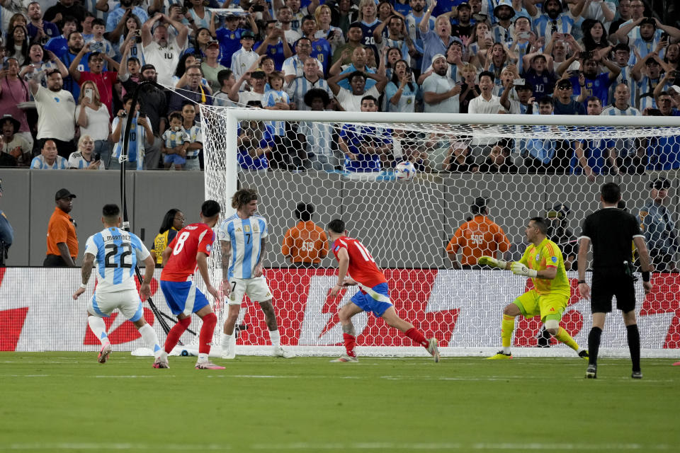 Argentina's Lautaro Martinez (22) scores the opening goal against Chile during a Copa America Group A soccer match in East Rutherford, N.J., Tuesday, June 25, 2024.(AP Photo/Pamela Smith)