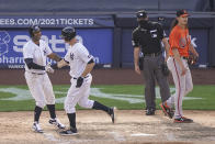 New York Yankees' DJ LeMahieu, center left, scores the winning run on an RBI sacrifice fly by Luke Voit off Baltimore Orioles relief pitcher Hunter Harvey, right, in the 10th inning of a baseball game, Saturday, Sept. 12, 2020, in New York. (AP Photo/John Minchillo)