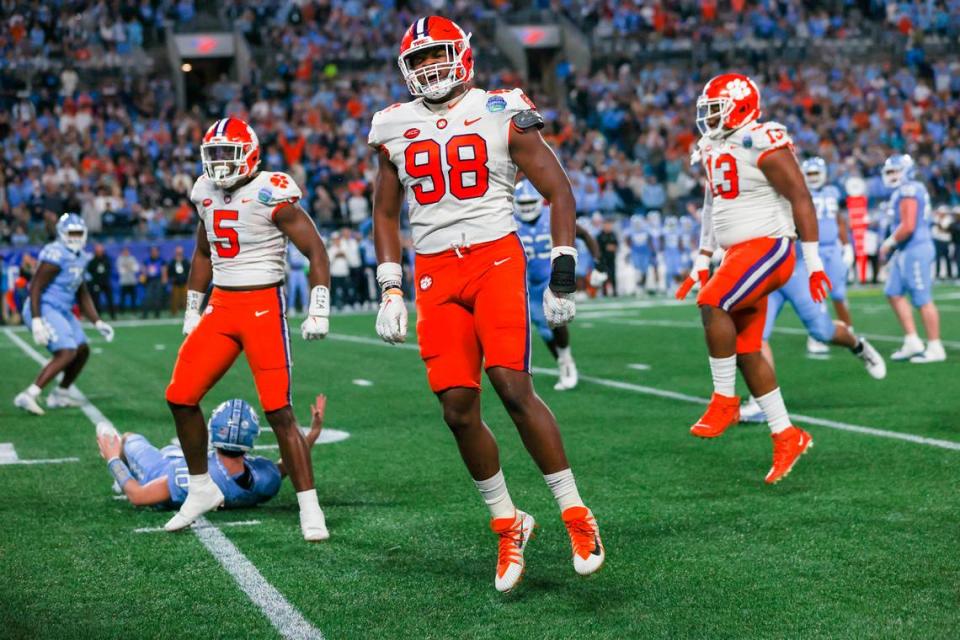 Clemson Tigers defensive ends K.J. Henry (5), and Myles Murphy (98) and defensive tackle Tyler Davis celebrate against the North Carolina Tar Heels at the 2022 ACC Championship in Charlotte, N.C., Saturday, Dec. 3, 2022. (Photo by Taylor Banner/ACC)