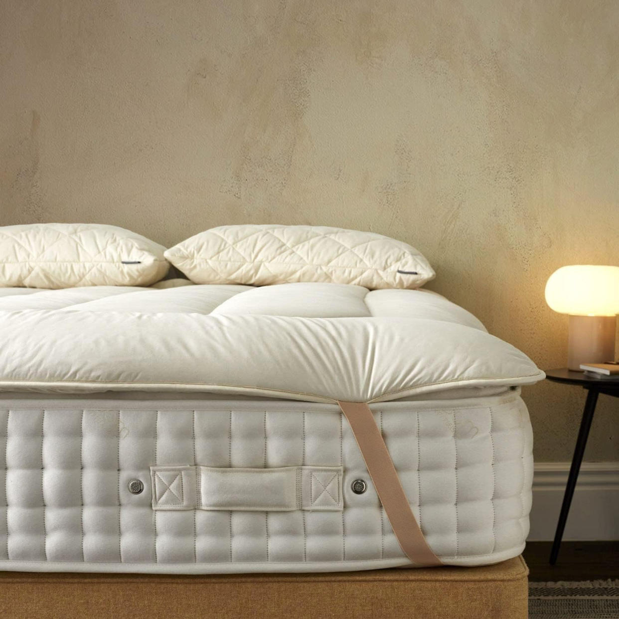  A Woolroom mattress topper on top of a mattress. 