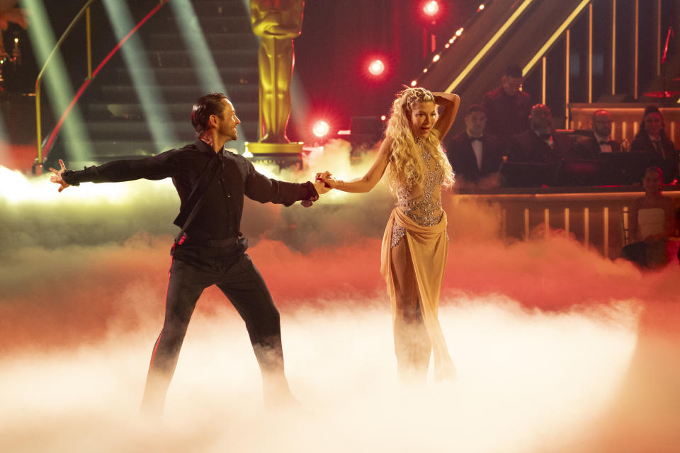 Pro dancer Pasha Paskov, left, and actress Tori Spelling dance onstage. 