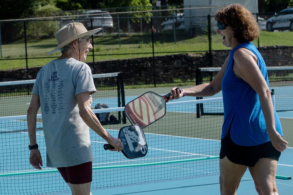 Donna Kelly, left, and Melinda Splain congratulate each other on a point as they play pickleball at Murphy-Oakley Park in Asheville June 17, 2022.