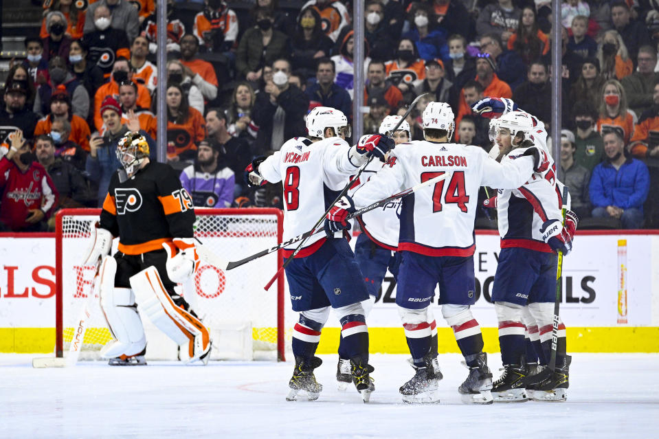 Washington Capitals' T.J. Oshie, right, celebrates with teammates after scoring a goal past Philadelphia Flyers goaltender Carter Hart, left, during the second period of an NHL hockey game, Saturday, Feb. 26, 2022, in Philadelphia. (AP Photo/Derik Hamilton)