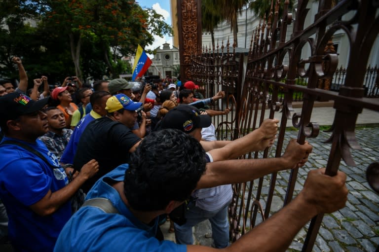 Supporters of Venezuelan President Nicolas Maduro break the gate and force their way to the National Assembly during an extraordinary session called by opposition leaders, in Caracas on October 23, 2016