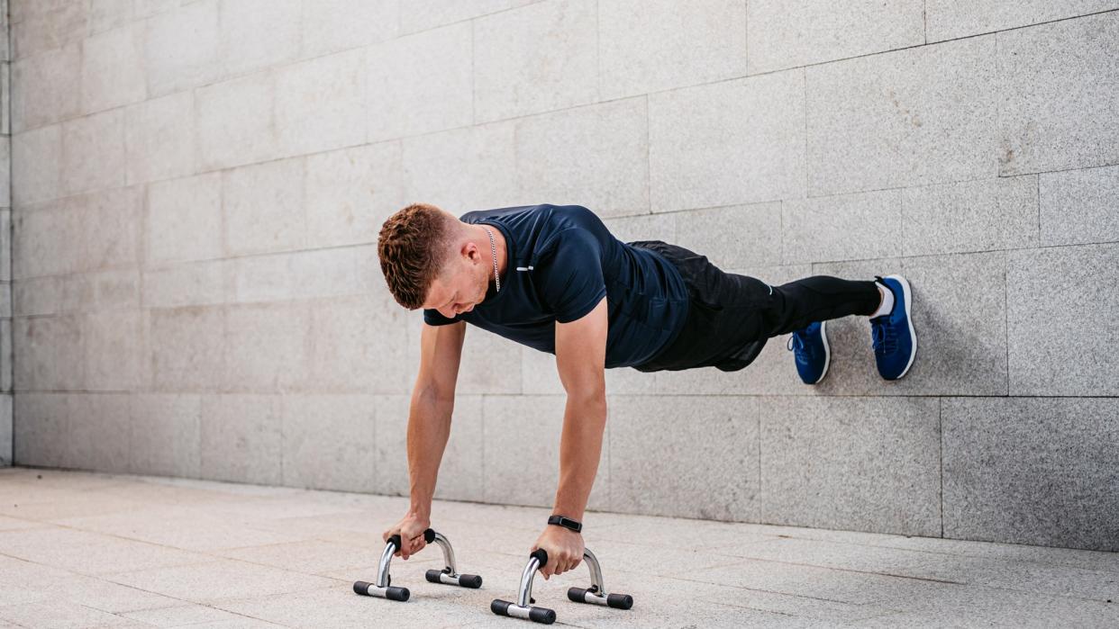  a photo of a man doing a wall plank 