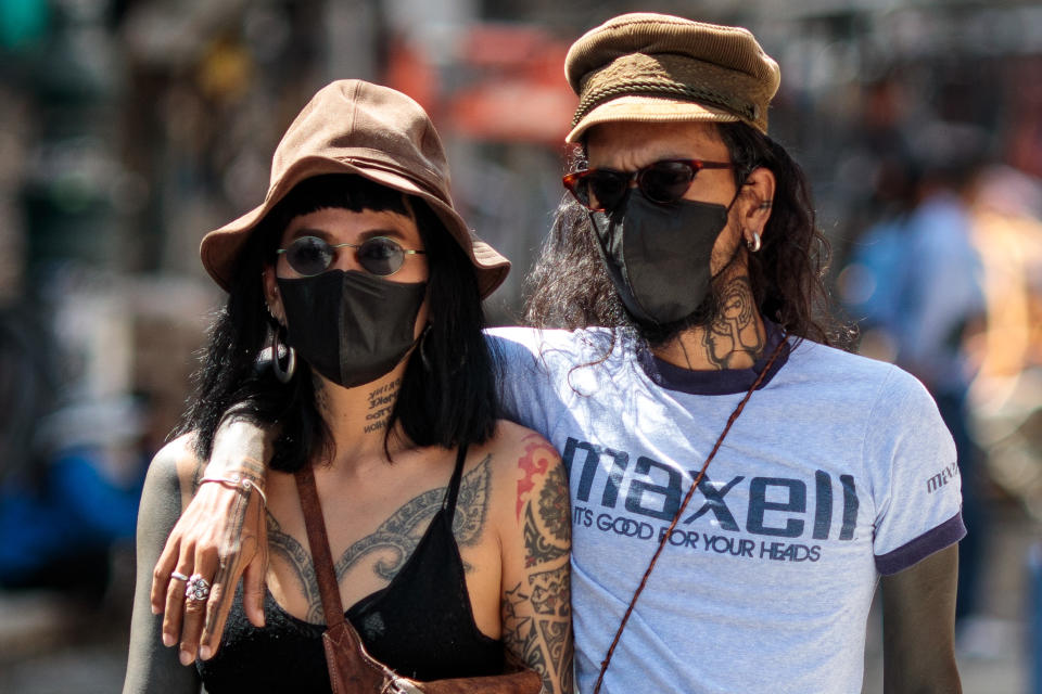Tourists wearing facemasks amid concerns over the spread of the COVID-19 novel coronavirus walk along Khao San Road, a popular area for tourists in Bangkok on March 6, 2020. (Photo by Jack Taylor / AFP) (Photo by JACK TAYLOR/AFP via Getty Images)