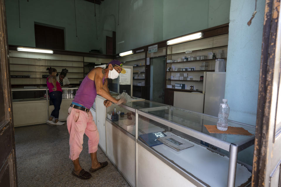 A man waits to be attended at a pharmacy amid the COVID-19 pandemic in Old Havana, Cuba, Thursday, July 15, 2021. Cuban President Miguel Díaz-Canel for the first time is offering some self-criticism while saying that government shortcomings in handling shortages and other problems played a role in this week's protests. (AP Photo/Eliana Aponte)