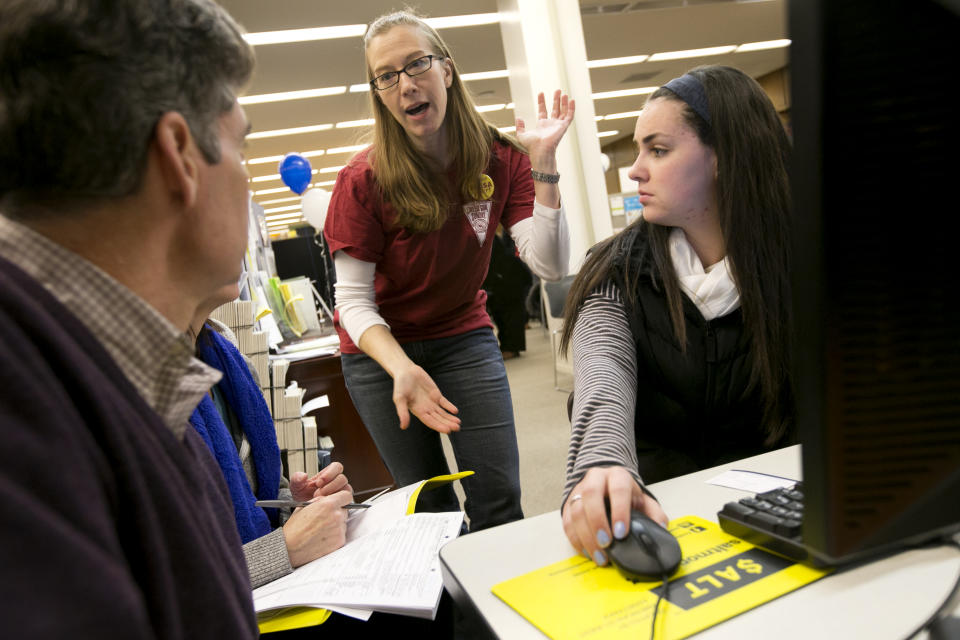 BOSTON - JANUARY 26: Liberty Collom, a Senior Assistant Director of Financial Aid at Boston University, center, spoke with Libby Doyle and her parents Steven, far left, and Elise as they filled out their FAFSA form. FAFSA Day took place at the Boston Public Library on Sunday, January 26, 2014. (Photo by Yoon S. Byun/The Boston Globe via Getty Images)