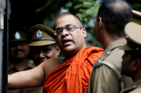 FILE PHOTO: Galagoda Aththe Gnanasara Thero, head of Buddhist group Bodu Bala Sena (BBS), walks towards a prison bus while accompanied by prison officers after he was sentenced by a court in Sri Lanka. June 14, 2018. REUTERS/Dinuka Liyanawatte/File Photo