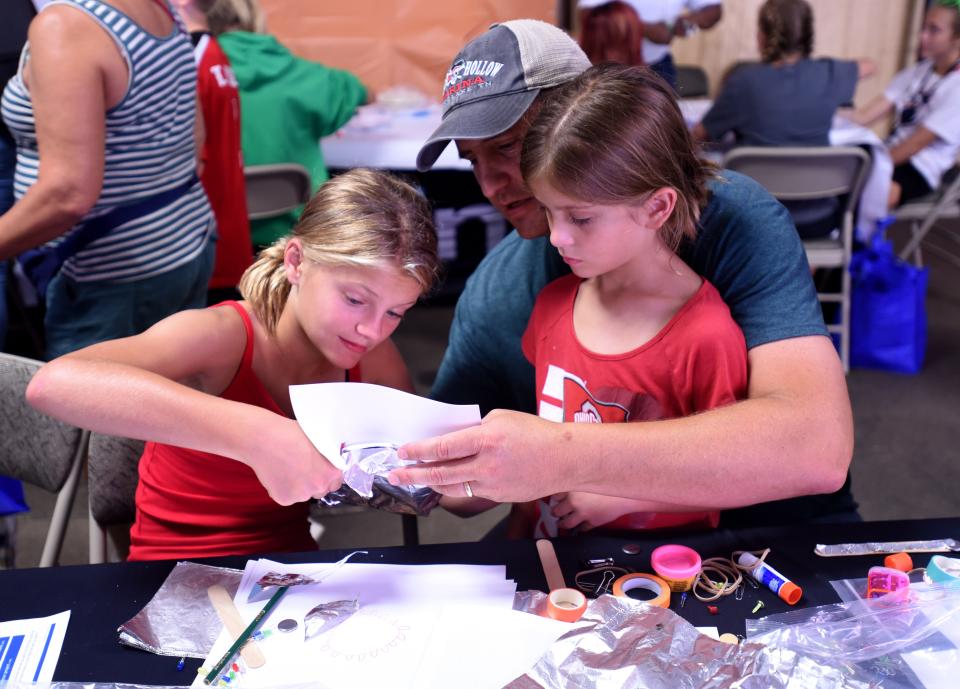 Dave Sahr works with daughters Sadie, 11, and Stella, 6, on a paper circuit project at Intel's booth at the Hartford Independent Fair on Wednesday, Aug. 10, 2022 at the Hartford Fairgrounds. Intel will host a both from 3 p.m. - 8 p.m. through Friday with stem activities, information, and other activities for Licking County families.