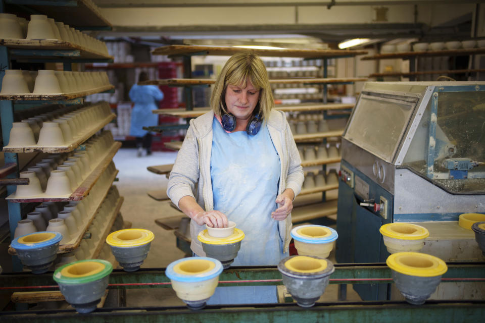 Turner Samantha Lloyd works, at the Duchess China 1888 factory, in Stoke-on-Trent, England, Thursday, March 30, 2023. With just five weeks to go until King Charles III’s coronation, an historic pottery is busy producing “God Save The King” commemorative china plates and mugs to mark the occasion. (AP Photo/Jon Super)