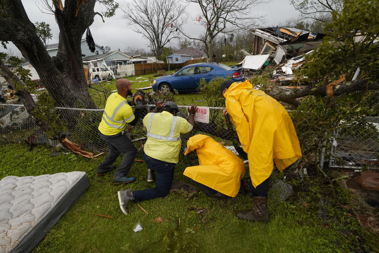 Workers shut off water amid destruction after a tornado tore through the area in Killona, La., about 30 miles west of New Orleans in St. James Parish, Wednesday, Dec. 14, 2022. (AP Photo/Gerald Herbert)