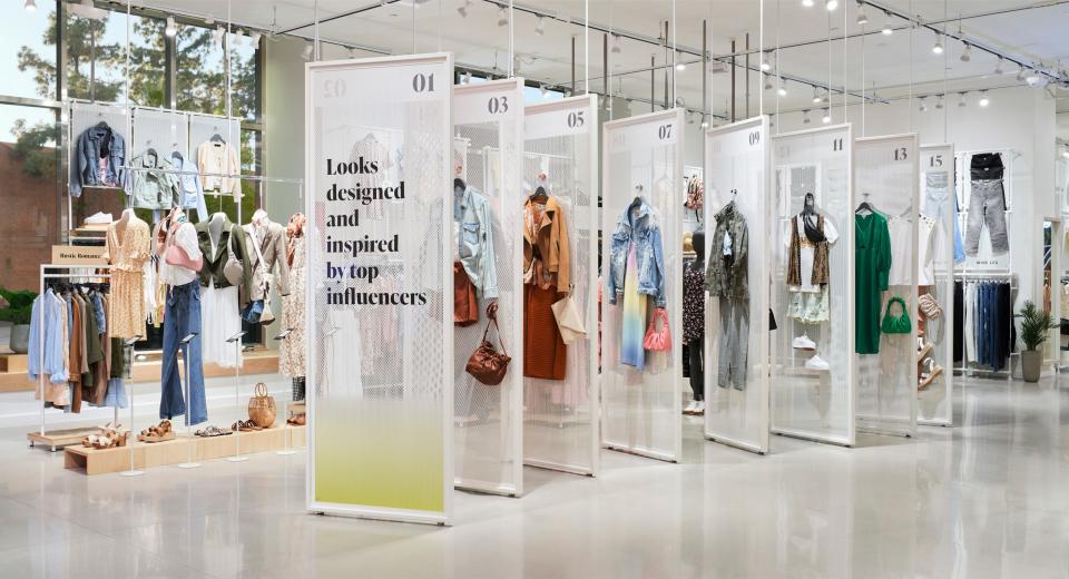 inside an Amazon Style store, several outfits hang on display walls