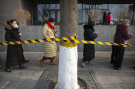 People wearing face masks to protect against the spread of the coronavirus line up for mass COVID-19 testing in a central district of Beijing, Friday, Jan. 22, 2021. Beijing has ordered fresh rounds of coronavirus testing for about 2 million people in the downtown area following new cases in the Chinese capital. (AP Photo/Mark Schiefelbein)