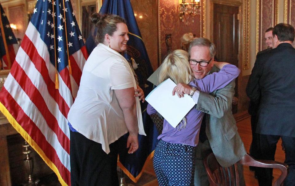 Utah Rep. Gage Froerer, a Republican from Huntsville who sponsored H.B.105 Plant Extract Amendments, hugs April Sintz, whose son Isaac has epilepsy, following the bill signing ceremony at the Utah State Capitol Tuesday, March 25, 2014, in Salt Lake City. Parents of Utah children with severe epilepsy are cheering a new state law that allows them to obtain a marijuana extract they say helps with seizures, but procuring it involves navigating a thorny set of state and federal laws. The new law doesn't allow medical marijuana production in Utah but allows families meeting certain restrictions to obtain the extract from other states. (AP Photo/Rick Bowmer)