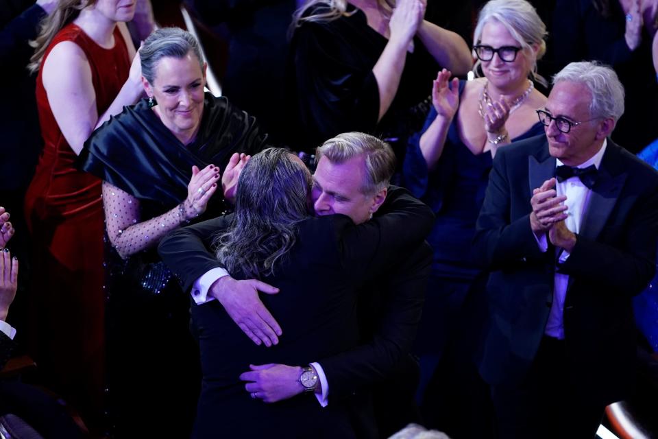 Christopher Nolan congratulates Hoyte van Hoytema as he walks to the stage to accept the award for achievement in cinematography for "Oppenheimer" during the 96th Oscars at the Dolby Theatre at Ovation Hollywood in Los Angeles on March 10, 2024.