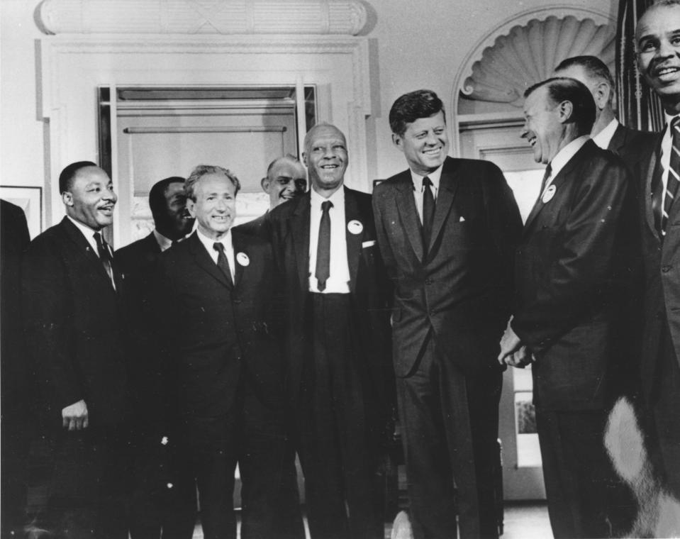 U.S. President John F. Kennedy in the White House in 1963 with leaders of the civil rights March on Washington (left to right): the Rev. Martin Luther King, John Lewis, Rabbi Joachim Prinz,  A. Philip Randolph, President Kennedy, Walter Reuther and Roy Wilkins. Behind Reuther is U.S. Vice-President Lyndon B. Johnson. / Credit: Getty Images