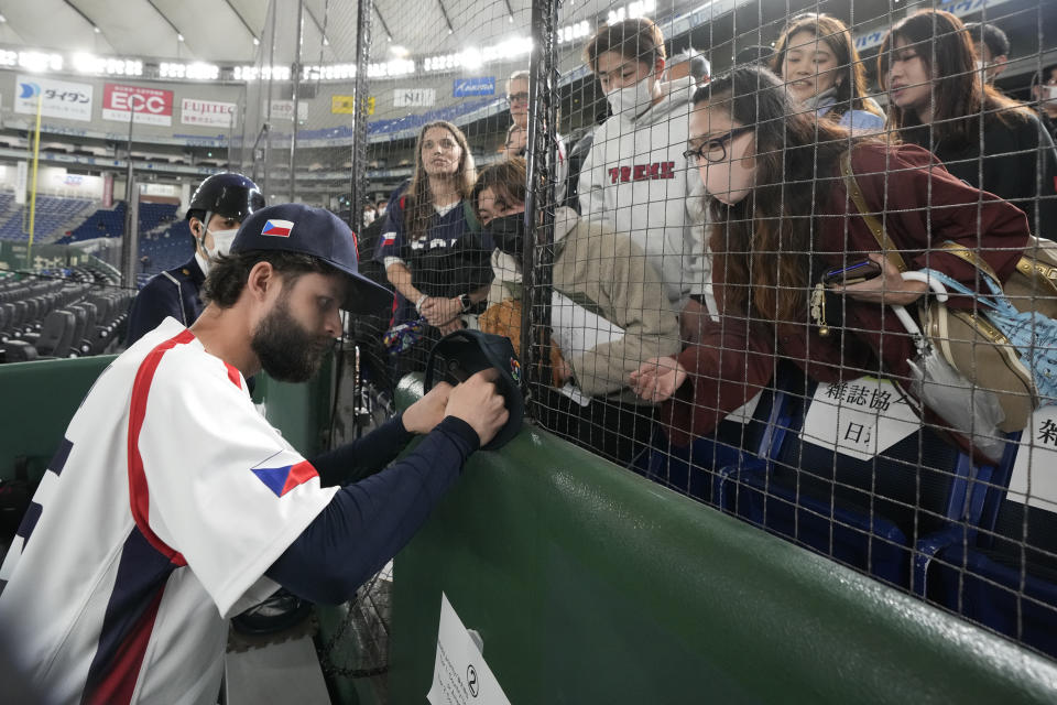 Ondrej Satoria, left, of Czech Republic, signs autographs for fans after the Pool B game between Australia and the Czech Republic at the World Baseball Classic at Tokyo Dome in Tokyo, Japan, Monday, March 13, 2023.(AP Photo/Shuji Kajiyama)