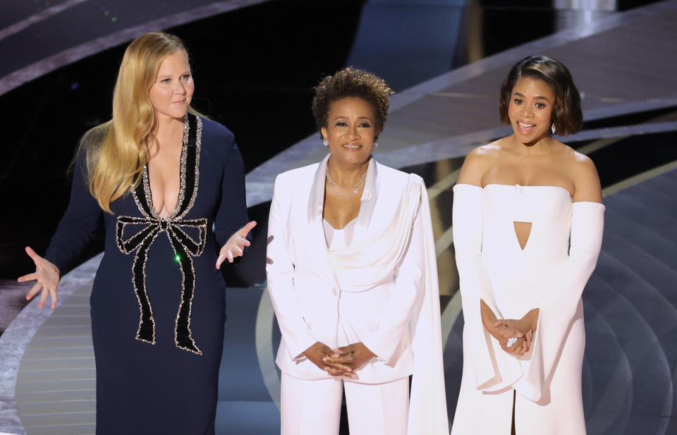 L–R: Co-hosts Amy Schumer, Wanda Sykes, and Regina Hall speak onstage during the 94th Annual Academy Awards at Dolby Theatre on March 27, 2022 in Hollywood, Calif. - Credit: Neilson Barnard/Getty Images