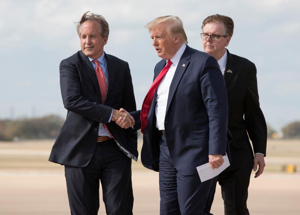 President Donald Trump is greeted by Texas Attorney General Ken Paxton, left, and Lt. Gov. Dan Patrick on a 2019 visit to Austin. Trump reiterated his support of Paxton on Saturday.